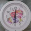 Videostill eines Weckers weiß mit roten, rosa, lila Blumen