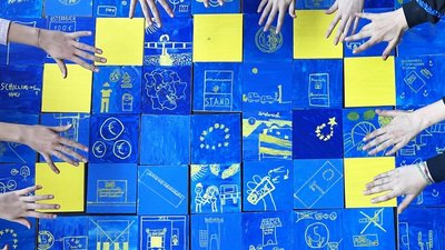 Das Bild zeigt eine Europa-Flagge mit Händen