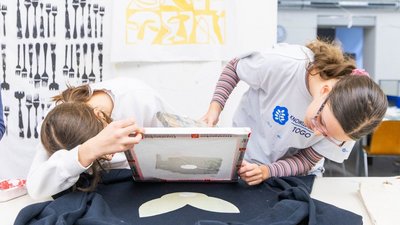 2 Schülerinnen arbeiten gemeinsam an einem Kunstprojekt