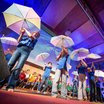 Dieses Bild zeigt einen szenischen Ausschnitt eines Theaterstücks mit Schüler/innen, Licht und Schirmen