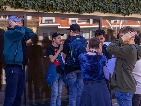 Eine Gruppe von Jugendlichen hält sich die Ohren zu