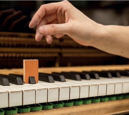 Fotografie einer Hand und einer Klaviertastatur