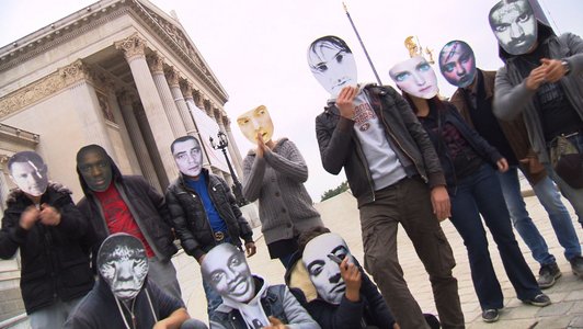 Foto von jungen Männern vor dem Parlament in Wien, die Fotomasken vor ihr Gesicht halten