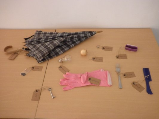 Foto von Gegenständen wie Regenschirm, Zwiebel, Glühbirne, Gabel, Kamm, Putzhandschuhen, Schlüssel etc.