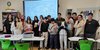 Gruppenbild in einem Klassenraum mit digitaler Schultafel.