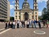 Schulklasse steht vor einem Dom.