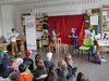 Kinder lesen aus verschiedenen Positionen wie z.B. am Stuhl, von rechst, von links oder in der Mitte ein Stück vor der Klasse vor.