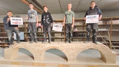 5 Schüler stehend auf einer selbst gemauerten Brücke
