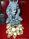 Skulptur eines grünen Werwolfs auf Totenschädel