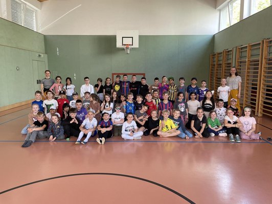 Schulklassen und zwei Lehrerinnen in Turnsaal