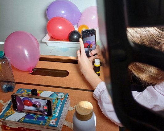 Nahaufnahme von Luftballonen, die von einem Handy fotografiert werden.