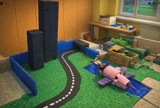 Foto von verschiedenen Stadtmodellen aus recyceltem Material, sowie ine Rakete und eine Straße.