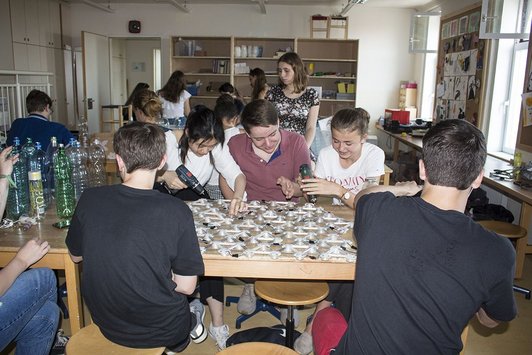 Foto von Schüler/innen im Werkraum, drei arbeiten an der Grundkonstruktion für die Lichtinstallation