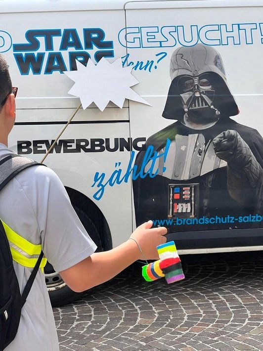 Schüler vor Schiebetür einem mit Werbung bedruckten Vans