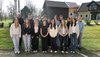 Gruppenfoto der Klasse auf einer Wiese vor einem gelben Wohhaus mit Scheune.