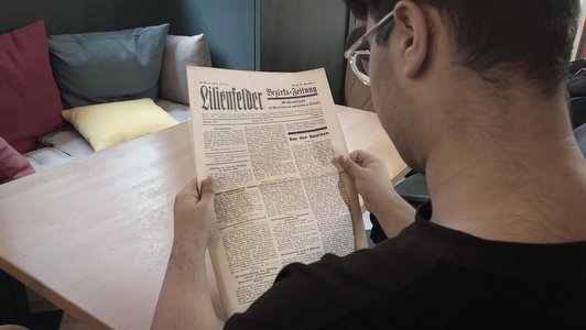 Jugendlicher liest Zeitung