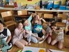 Kinder machen mit den Händen ein Herz vor einer selbstgebastelten Weltkugel.