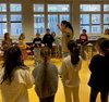 Eine Rapperin steht mitten im Raum und animiert die Schüler/innen sich zu bewegen.