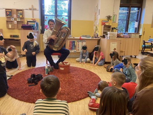 Musiker spielt auf einer Tuba vor der Klasse