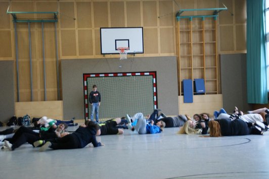 Rolling over the floor, laughing. 