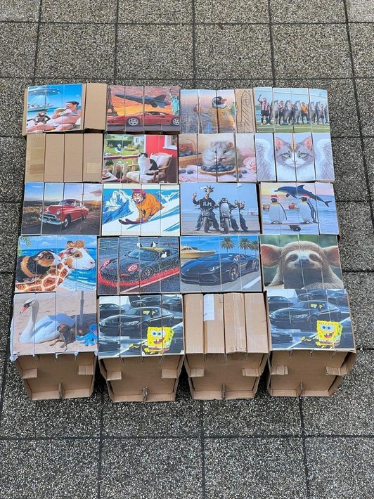 Foto von 20 Würfeln aus Karton mit Bildern drauf.