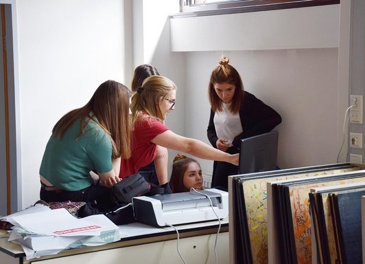 Foto von fünf Schülerinnen vor einem Bildschirm und Drucker