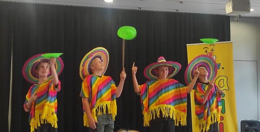 vier Buben in mexikanischen Ponchos und Hut jonglieren mit einem Teller