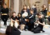 Foto von einer Kulturvermittlerin und 9 Schüler/innen, mit Rhythmusinstrumenten im Konzertsaal