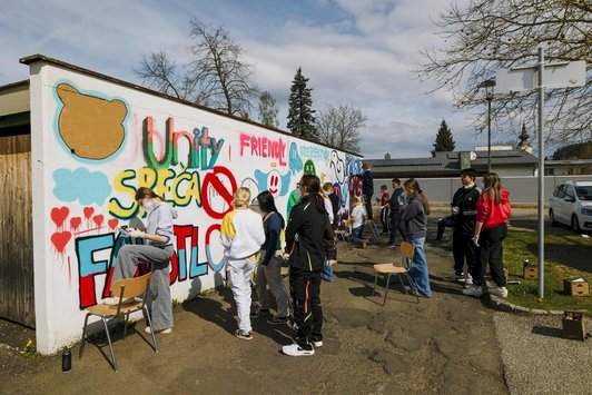 Jugendliche vor Wand voller bunter Graffiti