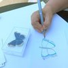 Eine Hand zeichnet einen Schmetterling