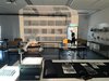 Referent kommt durch eine Tür in ein Fotostudio mit vielen Negativen, im Raum sind Tische und Stühle für einen Workshops.
