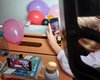 Nahaufnahme von Luftballonen, die von einem Handy fotografiert werden.