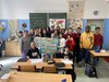 Gruppenfoto einer Schulklasse im Klassenzimmer mit dem Ergebnis in der Hand