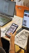 Ein Handy wird auf einen Laptop gerichtet