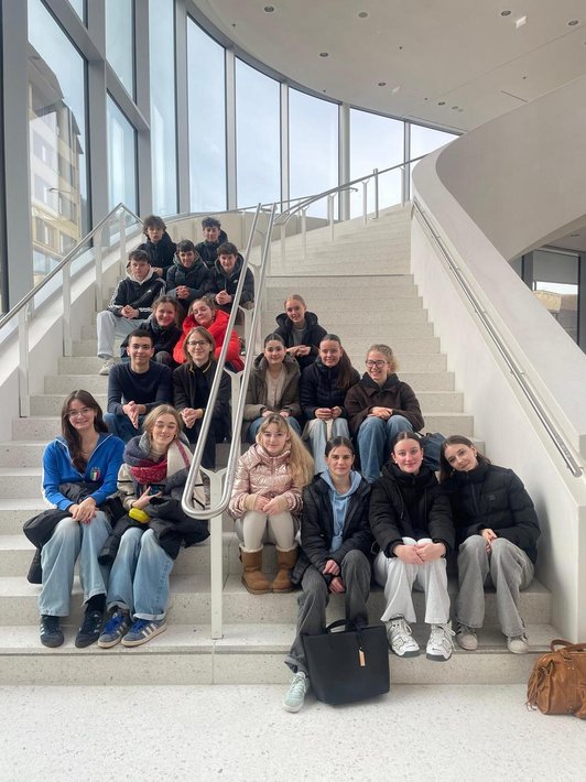 Jugendliche sitzen auf der Treppe im Eingangsbereich im Montforthaus
