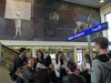 Foto der Schüler/innen und Vermittlerinnen neben der Rolltreppe unter den Fresken von G. Hoke im Klagenfurter Bahnhof