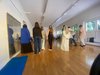 Junge Frauen stehen mit dem Rücken in einem großen Bewegungsraum mit Spiegel.