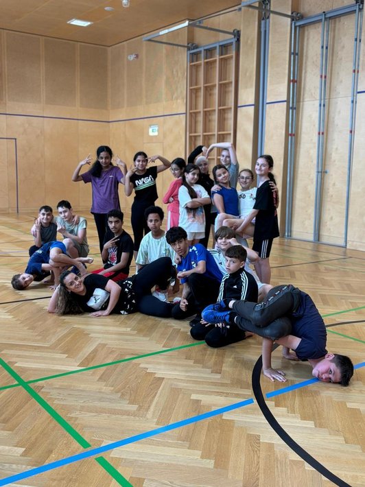 Gruppe von Schülerinnen posieren in Turnsaal für Foto