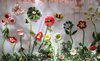 Foto von gestickten Blumen auf einem Tuch, hängend an einem Zaun