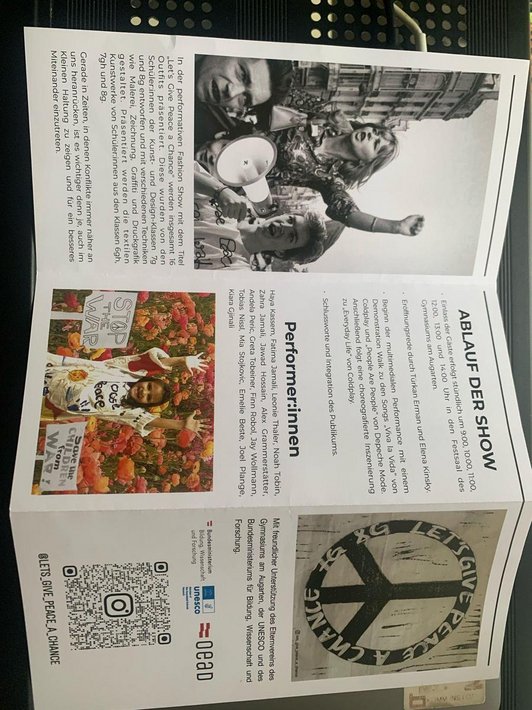 entfalteter Folder mit Fotos von Friedens-Protest und Text über Fashion Show