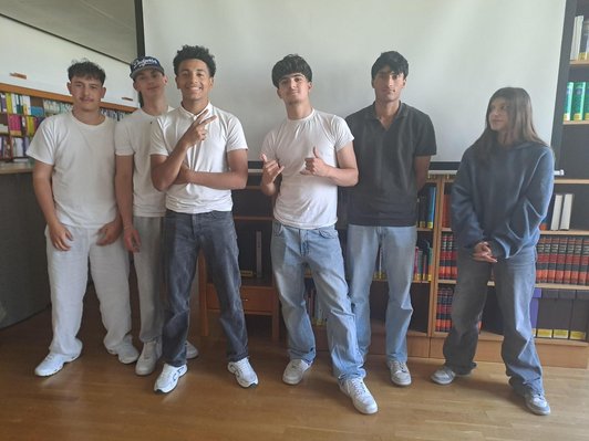 sechs Jugendliche stehen in Klassenzimmer