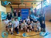 Schüler/innen im Hintergrund stehen auf Stelzen und vorne eine Gruppe Jugendlicher, die in der Hocke sind.