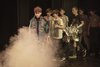 Musizierende Kinder, die von einem Theaternebel angesprüht werden.