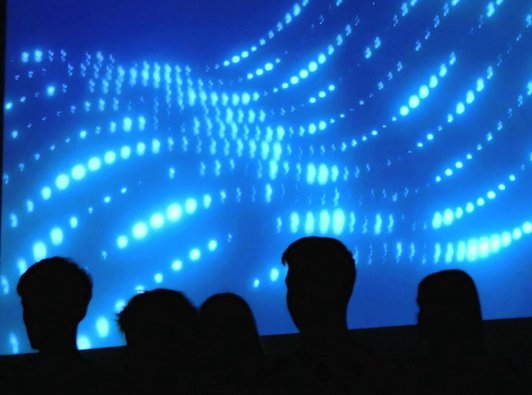 Projekten vpn blauer Wellengrafik teils verdeckt von Köpfen im Vordergrund