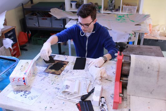 Foto eines Schülers beim Aufbringen der Druckfarbe auf die Ätzradierung