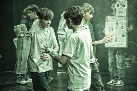 Schüler/innen in Szene, teils mit Roboter-Kostümen oder -Requsiten