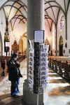 Foto einer Schülerin neben einem Postkartenständer im Inneren einer Kirche