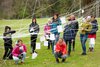 Foto von zehn Personen auf einer Wiese in einem Gebilde  aus Schnüren, an denen Zettel mit Kluppen aufgehängt sind