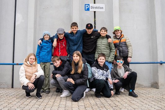 Gruppenfoto von 11 Schüler/innen auf Parkplatz