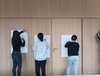 Drei Mädchen malen auf Plakate an der Wand